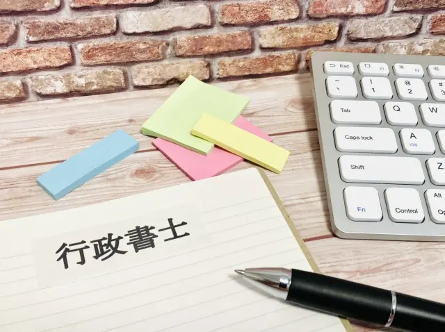 建設業許可 新規取得が完了し、行政書士と経営者が握手している様子。